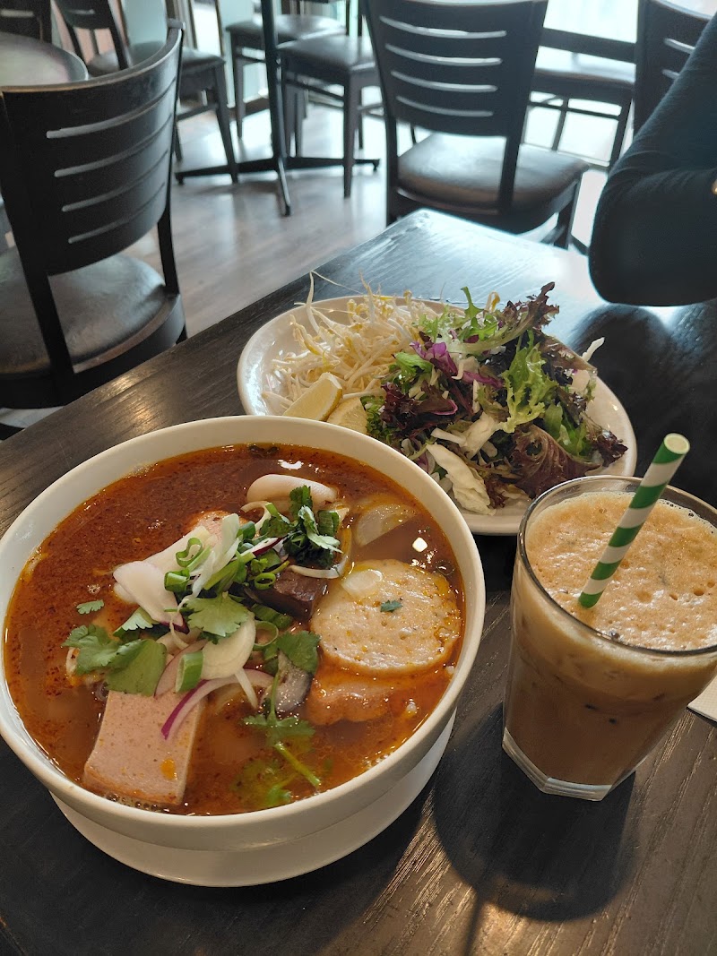 bowl of Hue-style spicy beef noodle soup with red lemongrass-chilli broth, thick round rice noodles, sliced beef, pork hock, congealed blood cube and herbs â Co Do, Richmond