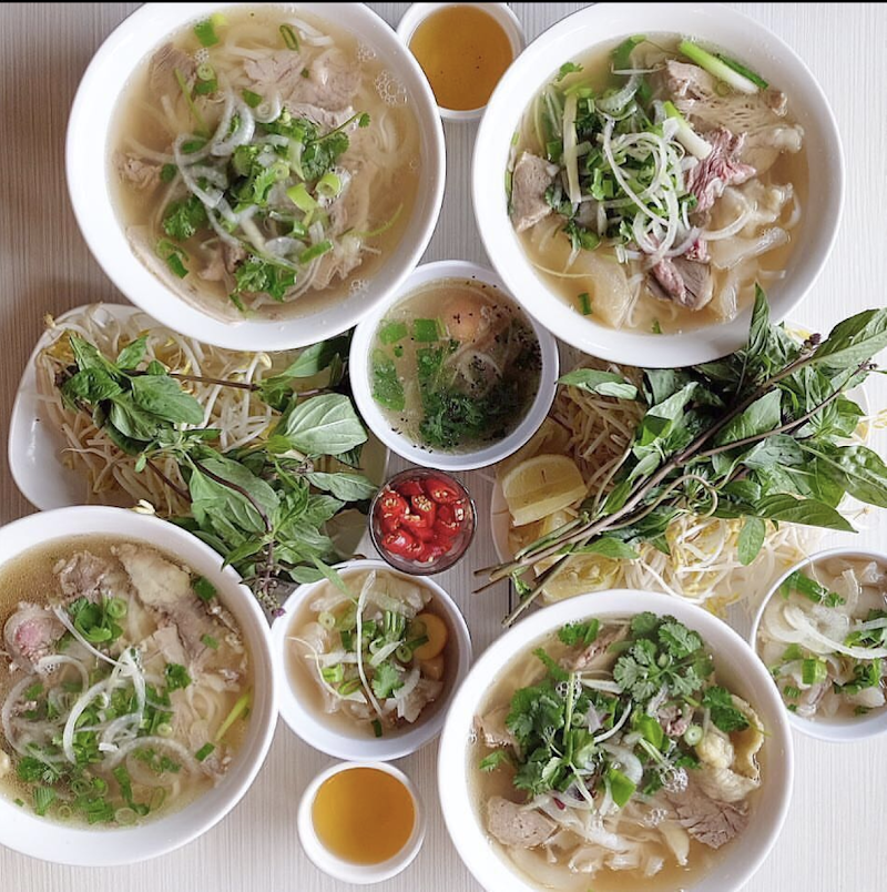 overhead flat-lay of multiple bowls of beef pho with herbs, bean sprouts, chilli and lime â Pho Chu The Richmond, Richmond
