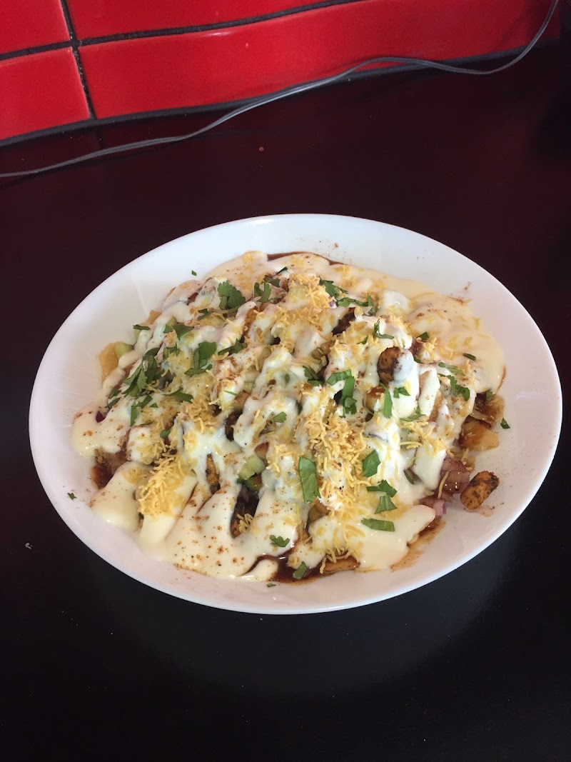 bowl of chaat (fried snack pieces) topped with yogurt, tamarind and mint chutney, sev and cilantro â Punjab Street, Springvale