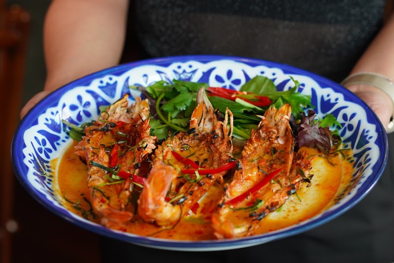 whole king prawns in a thick reddish curry-paste sauce with chili and herbs (restaurant's tom yum koong / curry-style prawn dish); no clean curry-bowl or clear tom yum soup shot existed among candidates â Thailand On Bourke, Melbourne CBD