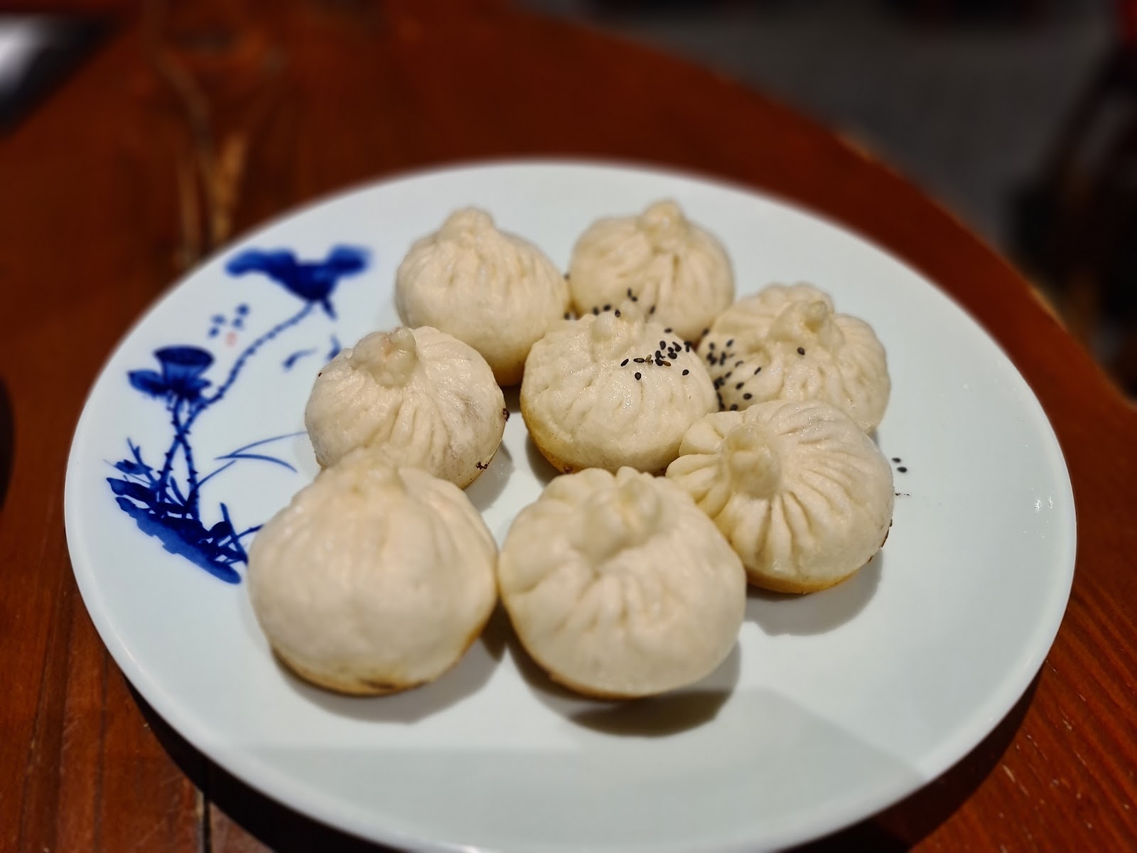 eight pan-fried shengjianbao, golden bases up, sesame and spring onion, on a blue-and-white plate â New Shanghai Chatswood, Chatswood