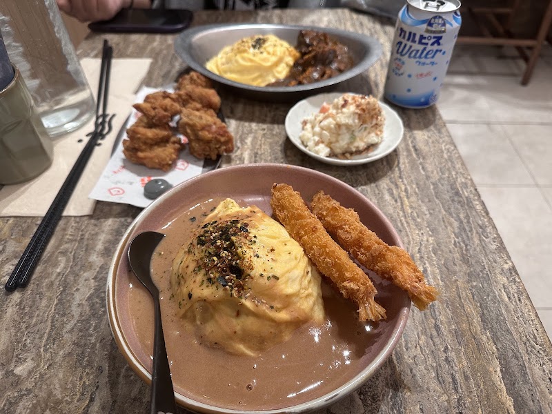 bowl of thick brown curry sauce poured over an omurice-style rice mound with two crumbed (ebi) cutlets alongside â Waku Waku, Melbourne CBD